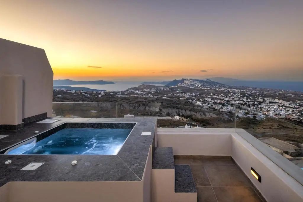 Ein kleiner Whirlpool auf einer Terrasse bei Sonnenuntergang mit Weitblick auf die Küste.