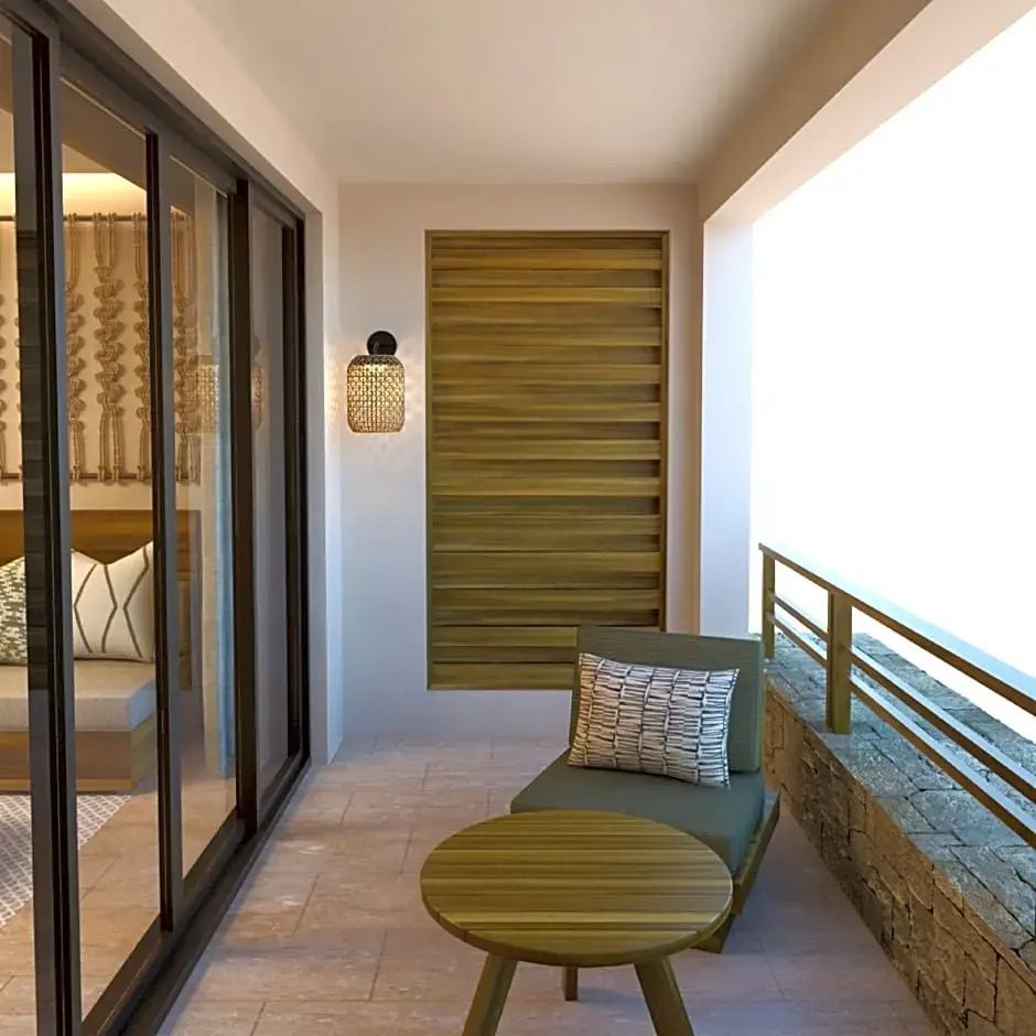 Balkon mit Sessel, kleinem Tisch und Holzelementen neben einer Schiebetür aus Glas.