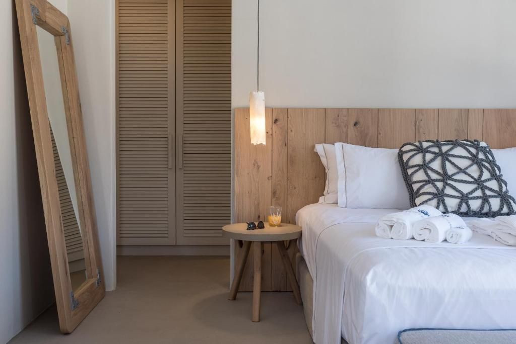 Schlafbereich mit Holzkopfteil am Bett, kleinem Nachttisch und Einbauschrank.