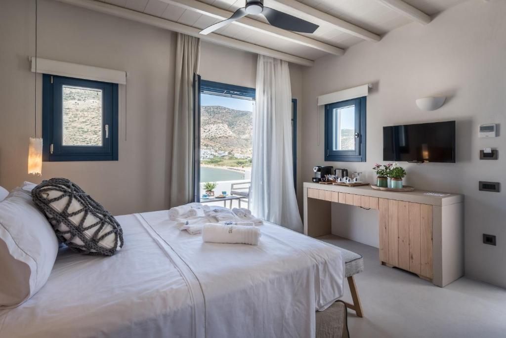 Hotelzimmer mit Schreibtisch, TV, Deckenventilator und Ausblick auf das Meer.