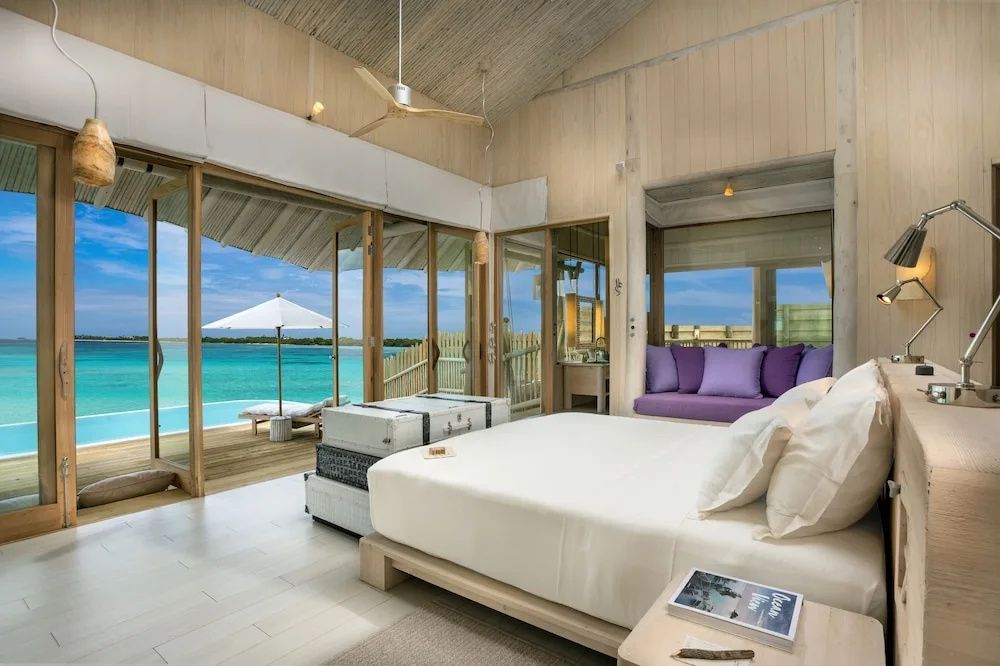 Blick vom hellen Schlafzimmer auf die Terrasse mit Pool und das Meer.