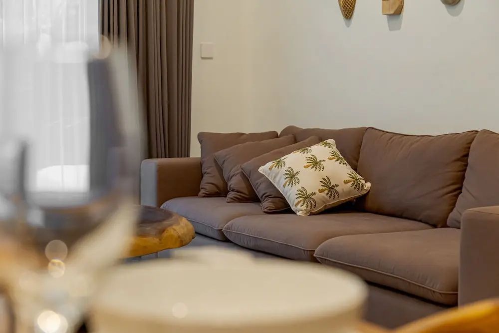 Braunes Sofa mit mehreren Kissen in einem modern eingerichteten Wohnbereich.