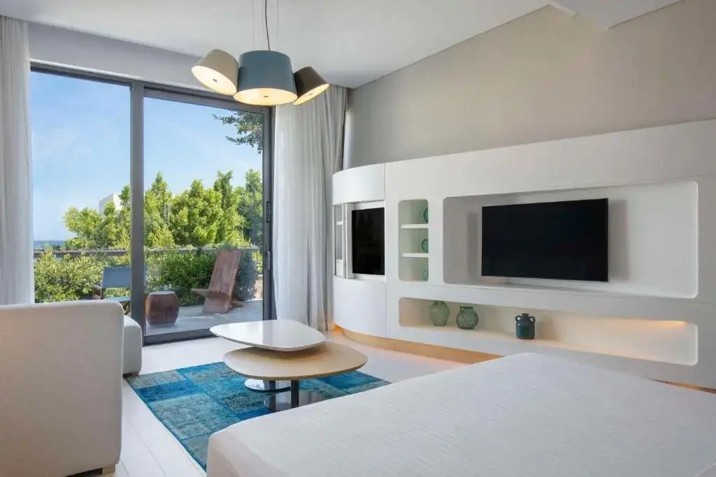 Schlafbereich und Wohnbereich mit Fernsehelement, Couchtisch und Terrasse.