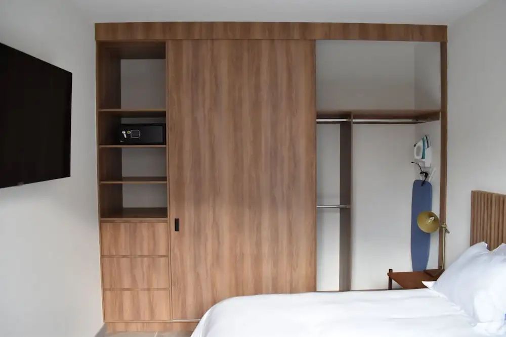 Großer Kleiderschrank aus Holz mit Schiebetür, Regalfächern und eingebautem Safe.