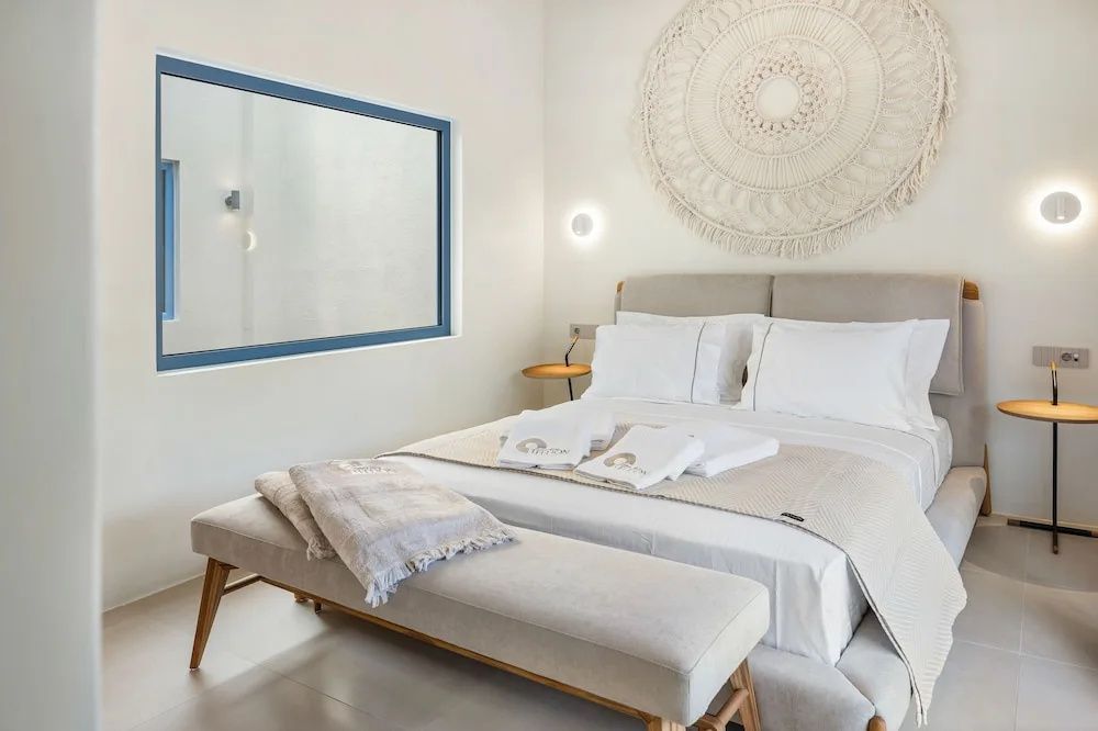 Helles Schlafzimmer mit modernem Doppelbett, weißer Bettwäsche und runder Wanddekoration.