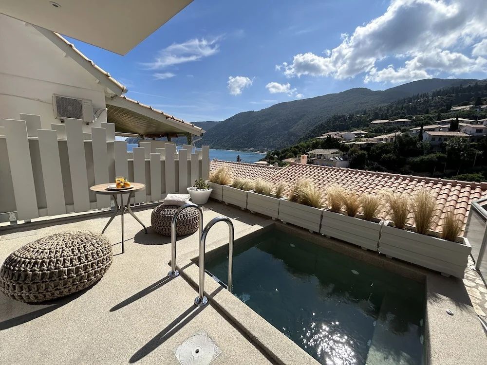 Terrasse einer Suite mit einem privaten Pool, Sitzkissen und Aussicht auf die Küste.