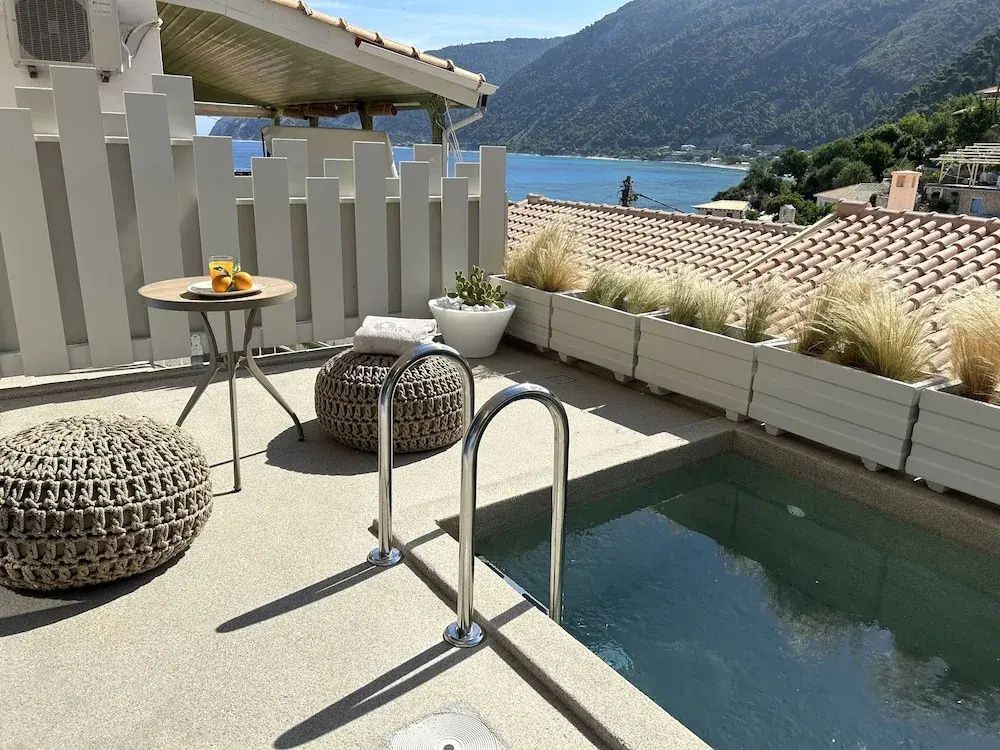 Terrasse mit kleinem Becken, Einstiegsleiter, Pflanzenkübeln und freiem Blick auf die Meeresbucht.
