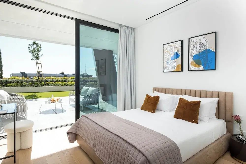Schlafzimmer mit Doppelbett und direktem Zugang zur sonnigen Terrasse.