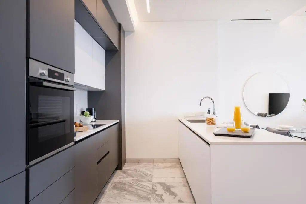 Moderne Einbauküche mit dunklen Schränken, hellem Arbeitsbereich und modernen Einbaugeräten.