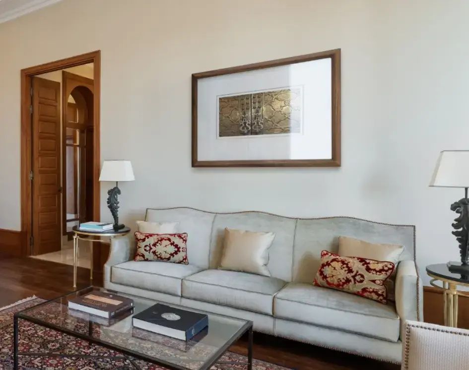 Bequemes Sofa mit orientalisch gemusterten Kissen und einem Glastisch.