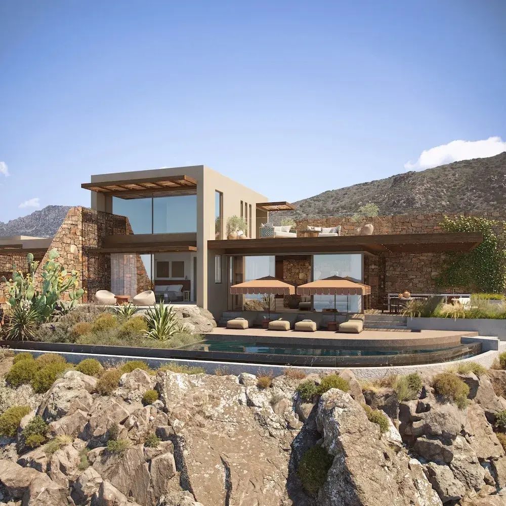 Moderne zweigeschossige Villa aus Naturstein und Putz auf einer felsigen Anhöhe mit Terrasse und Pool