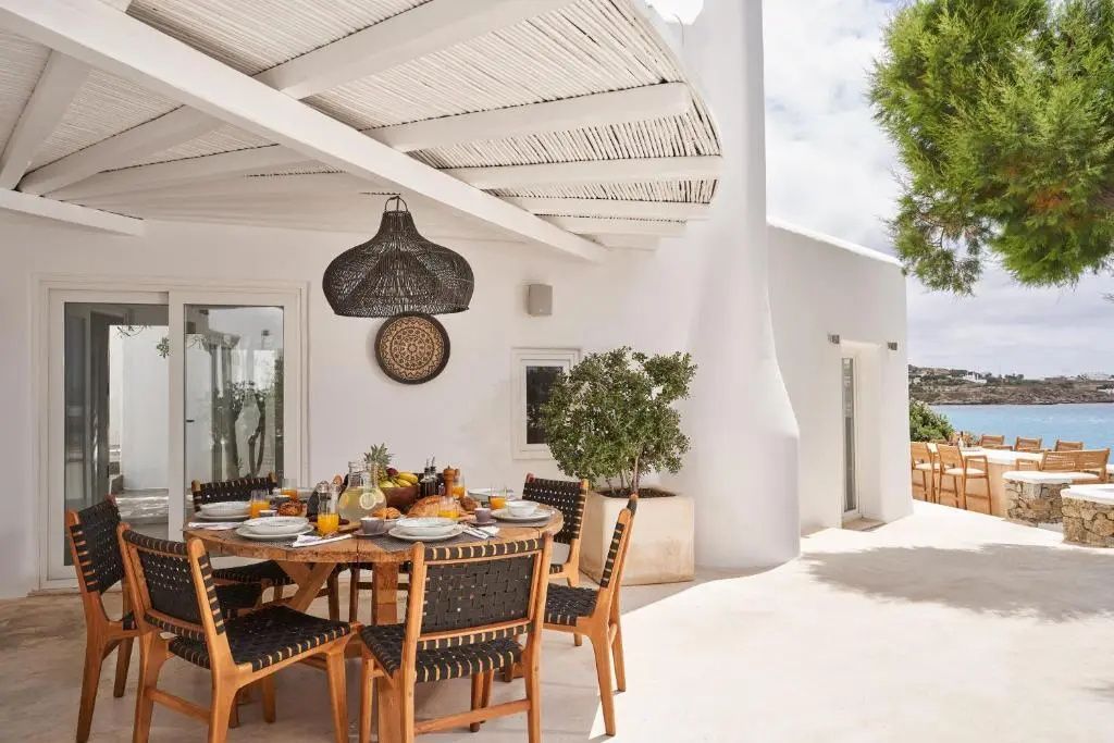 Überdachter Sitzbereich auf der Terrasse mit gedecktem Esstisch und Stühlen.