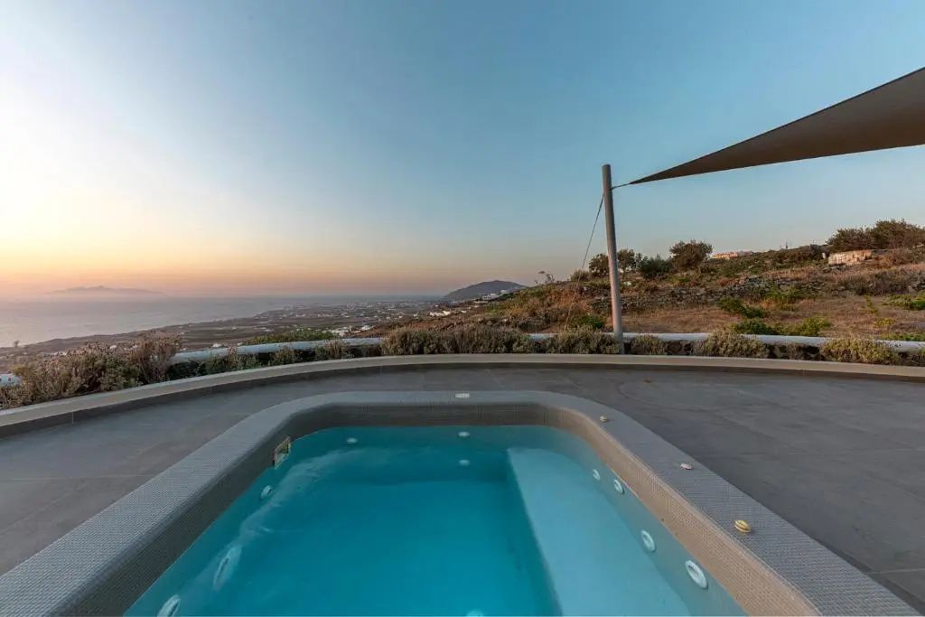 Ein Whirlpool auf der Terrasse mit Blick auf die umliegende Landschaft und das Meer.