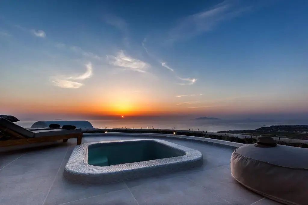 Ein Außen-Whirlpool auf einer Terrasse bei Sonnenuntergang mit Blick auf das Meer.