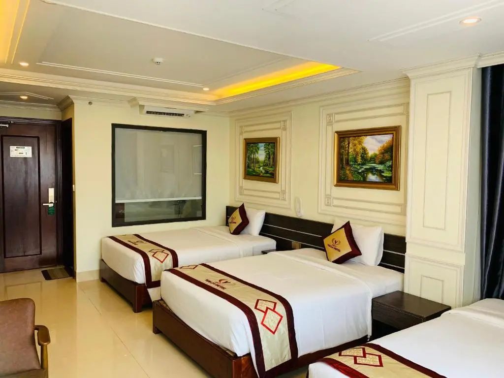 Einrichtungsbeispiel eines Hotelzimmers mit zwei Betten und Gemälden an der Wand.