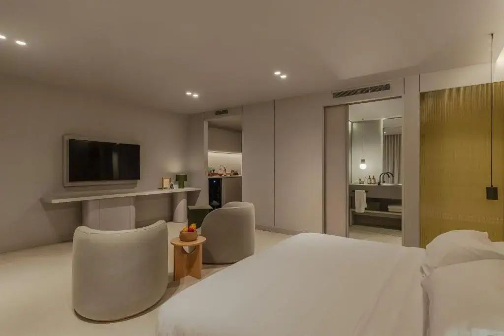 Blick durch das Hotelzimmer auf den Fernseher und den Durchgang zum Badezimmer.