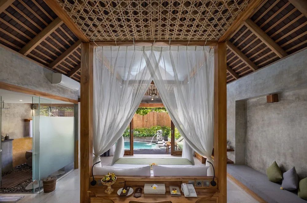 Blick aus dem Schlafzimmer mit Himmelbett auf die Terrasse und den Außenpool der Villa.