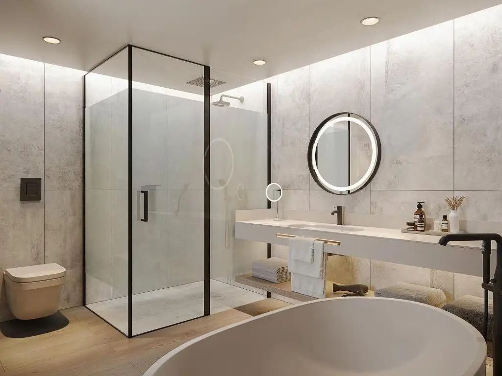 Modernes Badezimmer mit einer begehbaren Glasdusche, einem beleuchteten Rundspiegel und einer Badewanne.