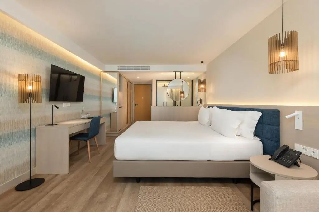 Geräumiges Doppelzimmer mit Holzfußboden, großem Bett und Wandfernseher