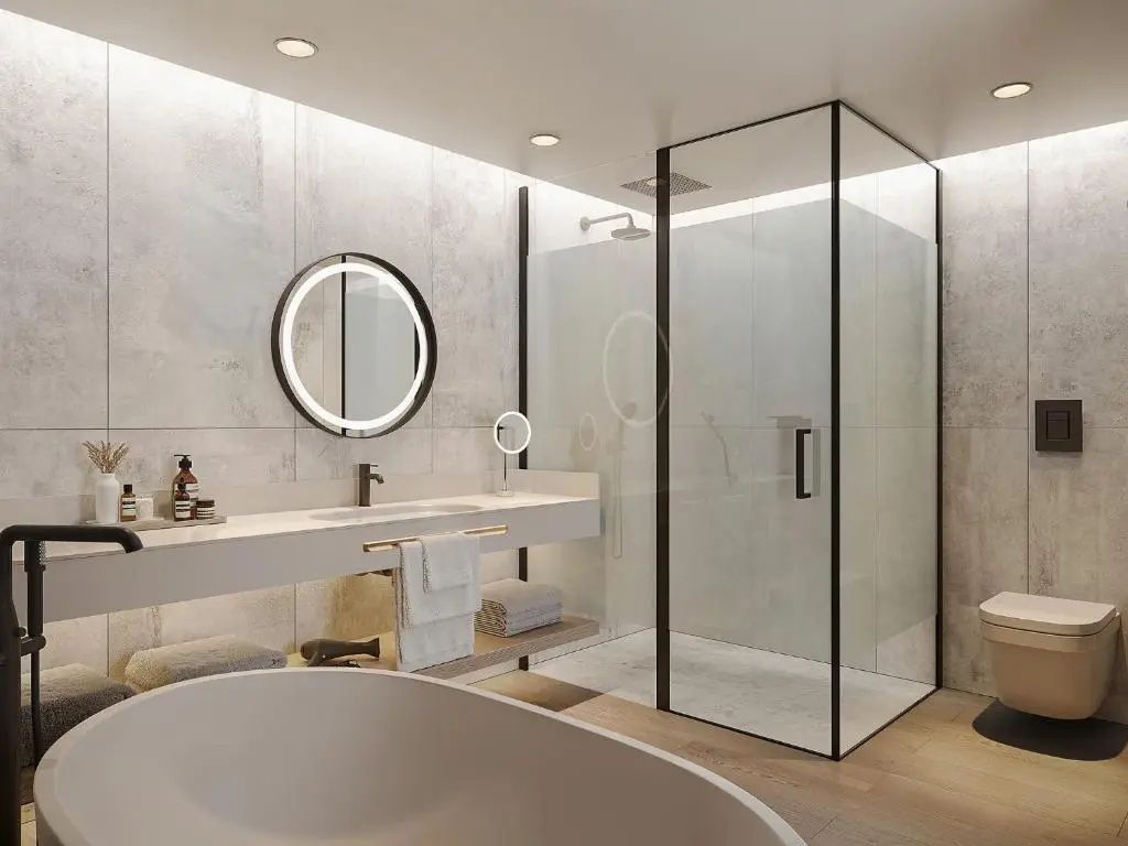 Modernes Badezimmer mit einer geräumigen Glasdusche, beleuchtetem Rundspiegel und freistehender Wanne.