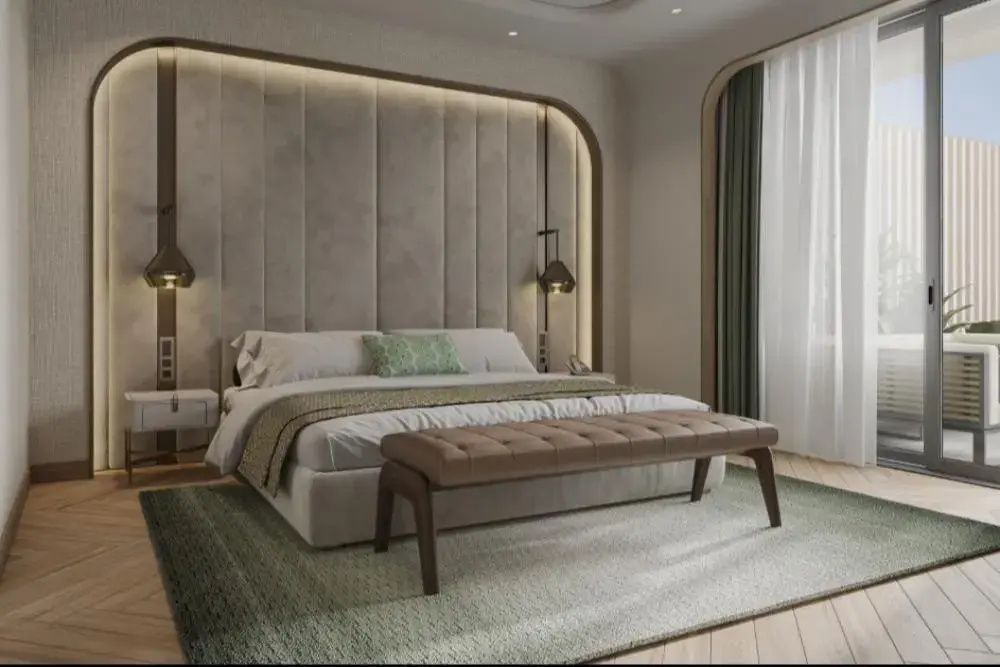 Doppelbett mit gepolstertem Kopfteil, Bettbank und Teppich im hellen Hotelzimmer.