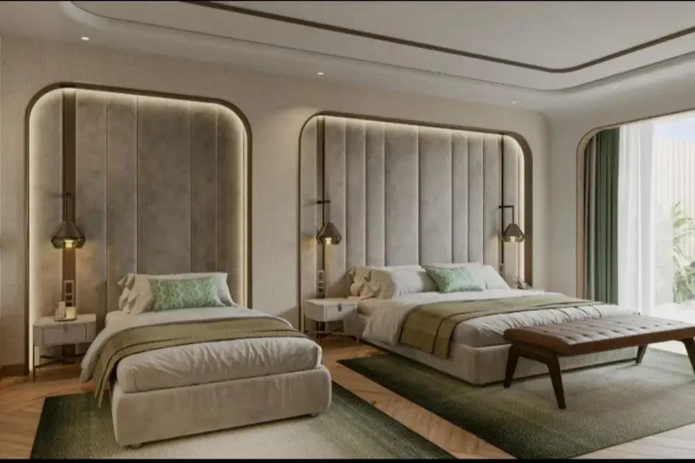 Hotelzimmer mit zwei Betten, gepolsterter Wandverkleidung und warmem Licht.