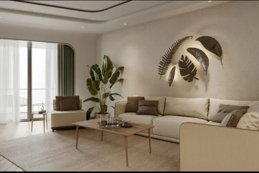 Wohnbereich mit beigefarbenem Sofa, Holzcouchtisch und Wanddekoration mit Blattmotiven.