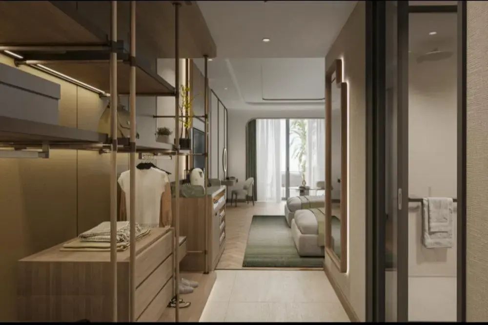 Blick durch den Ankleidebereich mit offenem Schrank in das angrenzende Schlafzimmer.