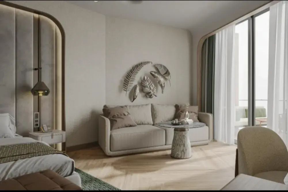 Sitzbereich im Zimmer mit einem beigen Sofa, einem runden Tischelement und Wanddekoration.