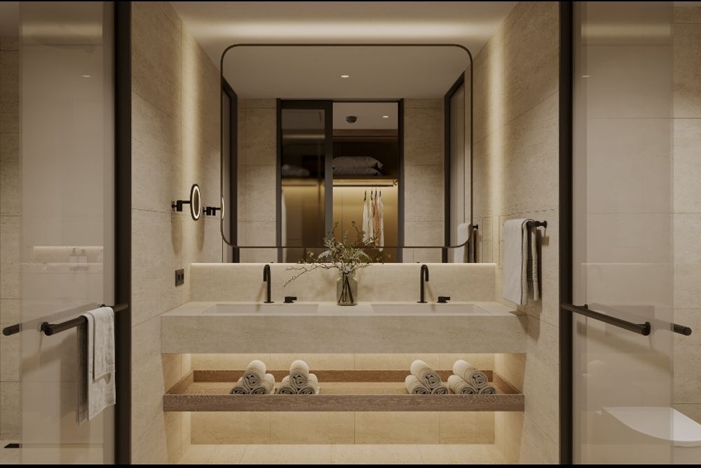 Badezimmer mit beigem Doppelwaschtisch, beleuchtetem Spiegel und eingerollten Handtüchern.