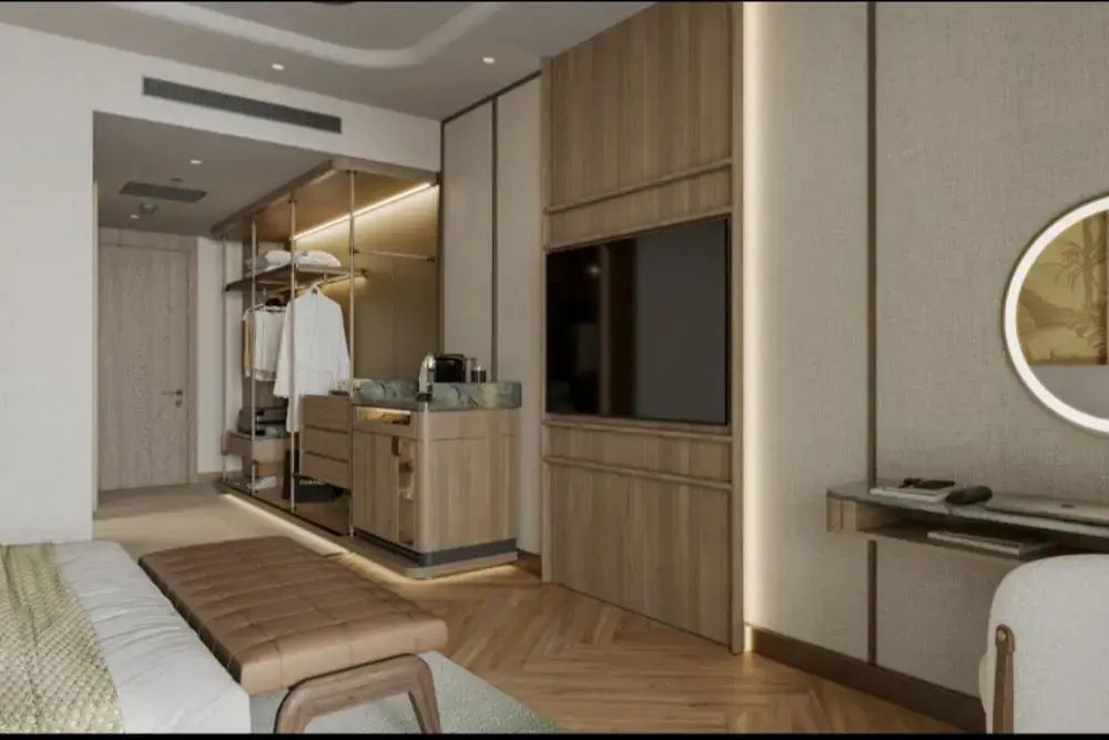 Wandmontierter Fernseher in Holzverkleidung und offener Kleiderschrankbereich im Hotelzimmer.