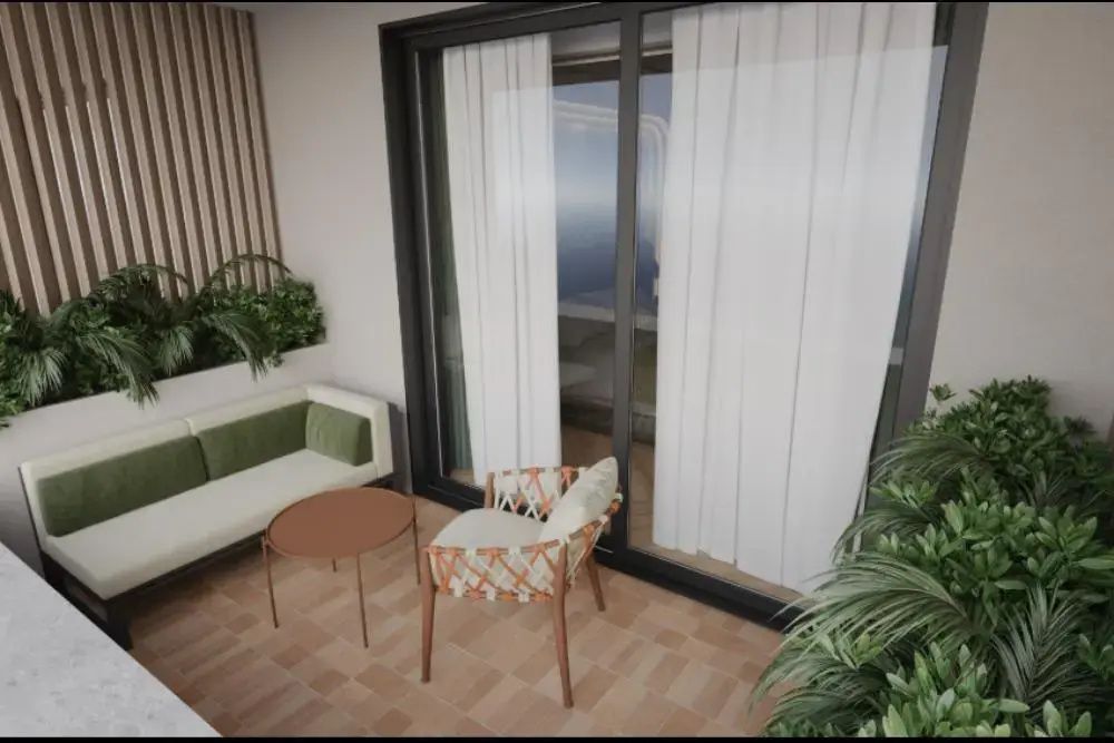 Balkonecke mit kleinem Beistelltisch, Polstersofa und geflochtenem Sessel.