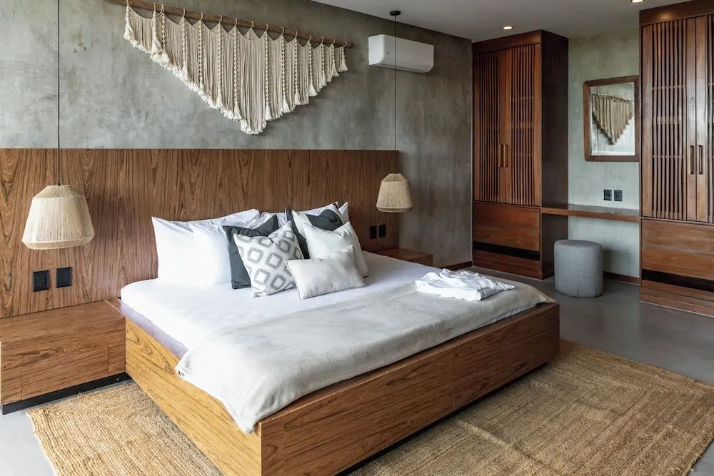 Doppelbett aus Holz mit Makramee-Wanddekoration und integriertem Kleiderschrank.
