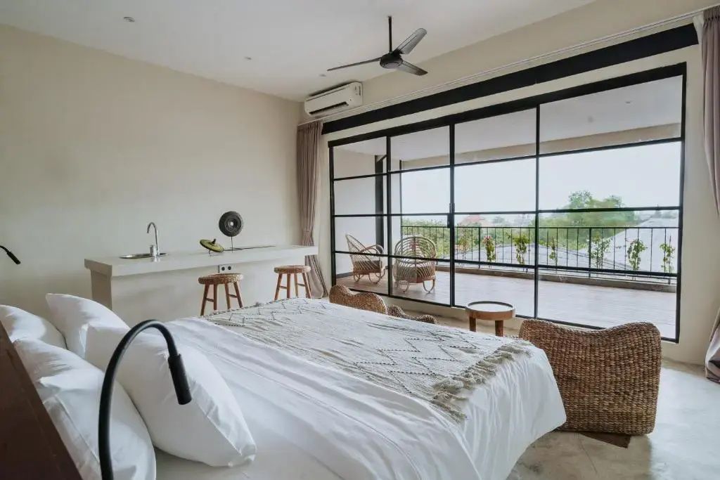 Hotelzimmer mit Blick auf die Glasschiebetür und den dahinterliegenden Balkon.
