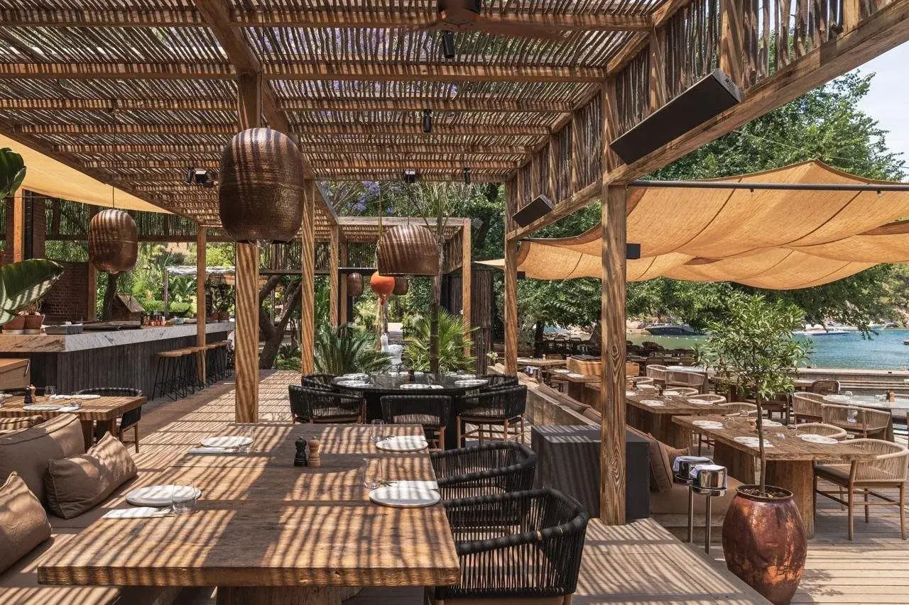 Boho Hotel in der Türkei: überdachte Terrasse aus Schilf und Holz mit Kupferlampen im Yazz Collective bei Fethiye