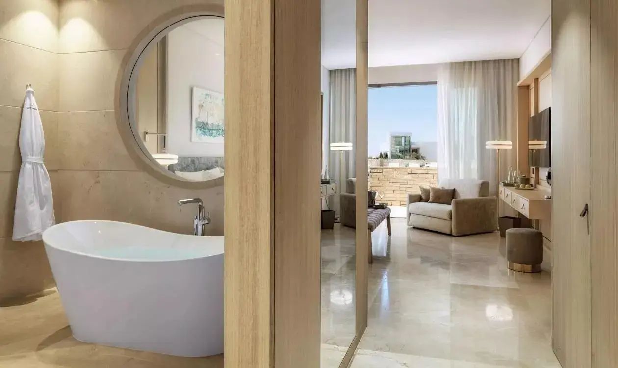 Blick aus dem Badezimmerbereich mit freistehender Badewanne in das angrenzende Zimmer.