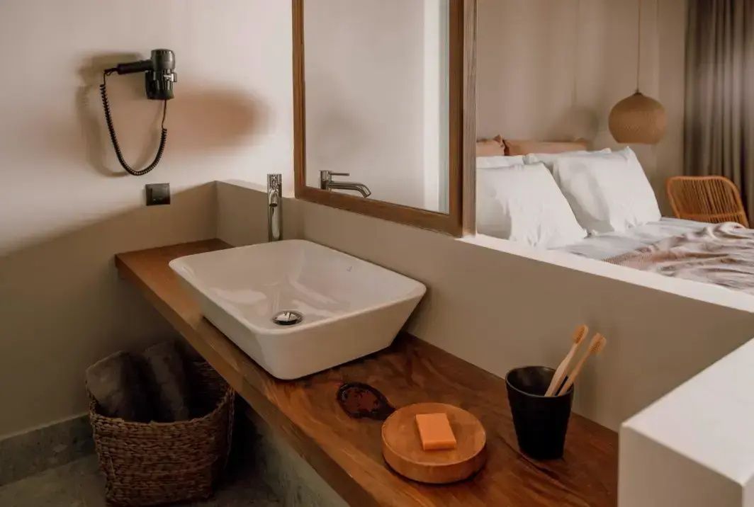 Weißes Aufsatzwaschbecken auf einer Holzkonsole mit Holzaccessoires