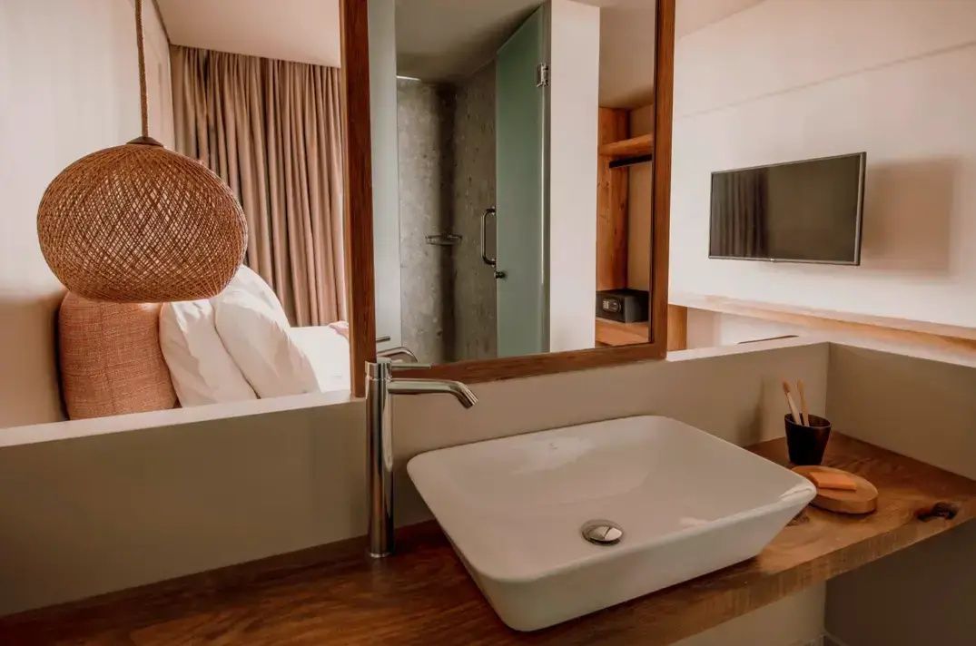 Modernes Aufsatzwaschbecken auf einer Holzkonsole mit einem großen Spiegel im Badezimmer.