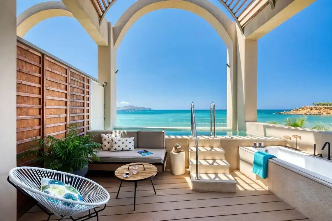 Überdachte Terrasse mit Sitzgelegenheiten, kleinem Pool und Ausblick auf das Meer.