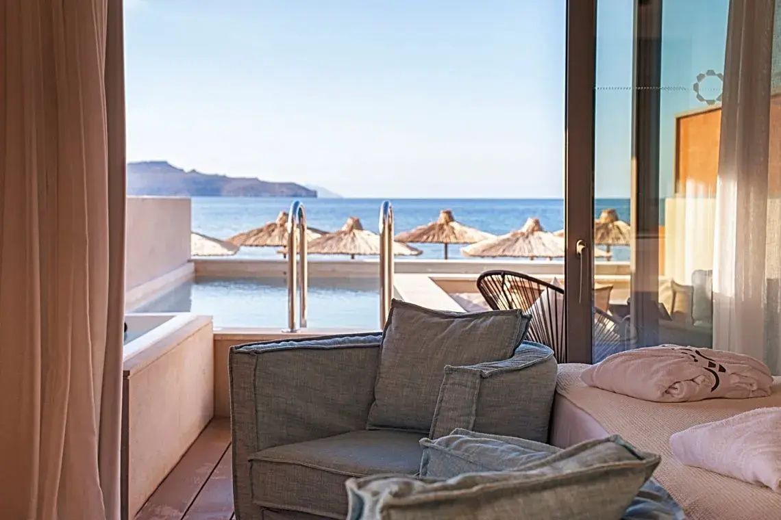 Sitzgelegenheit auf einer Terrasse mit eigenem kleinen Pool und Blick auf den Strand und das Meer.