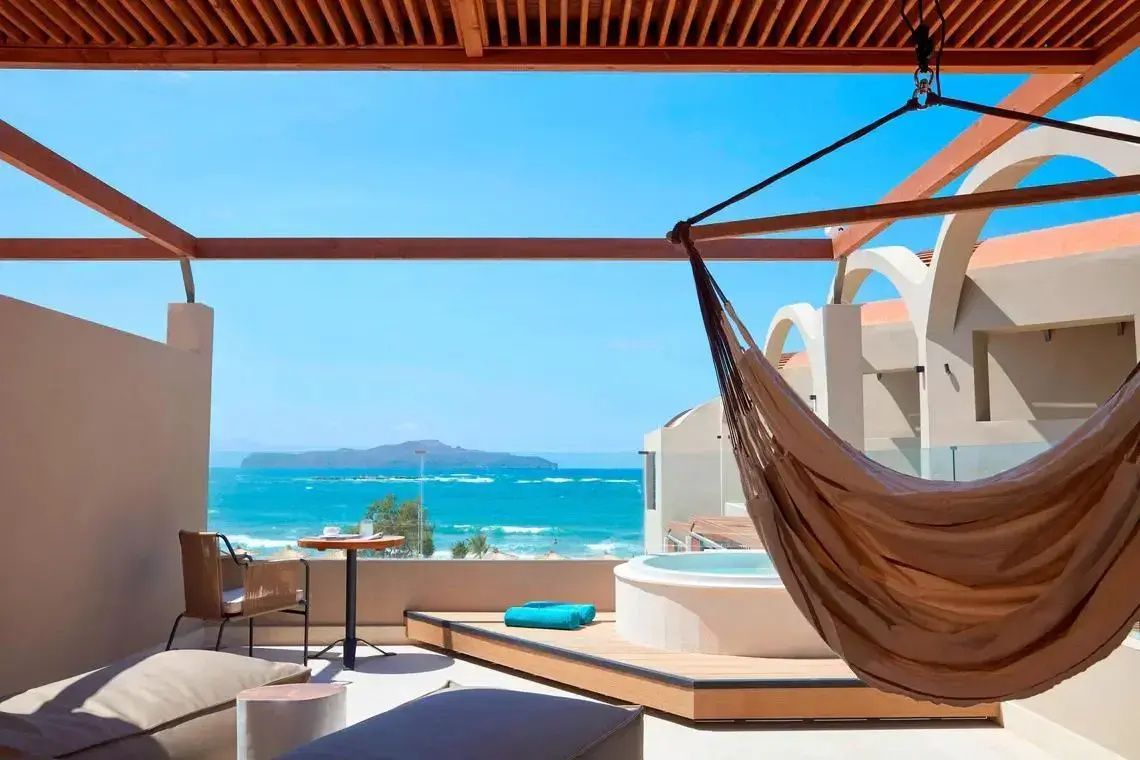 Überdachte Dachterrasse mit Hängematte, Whirlpool und freiem Blick auf das Meer.