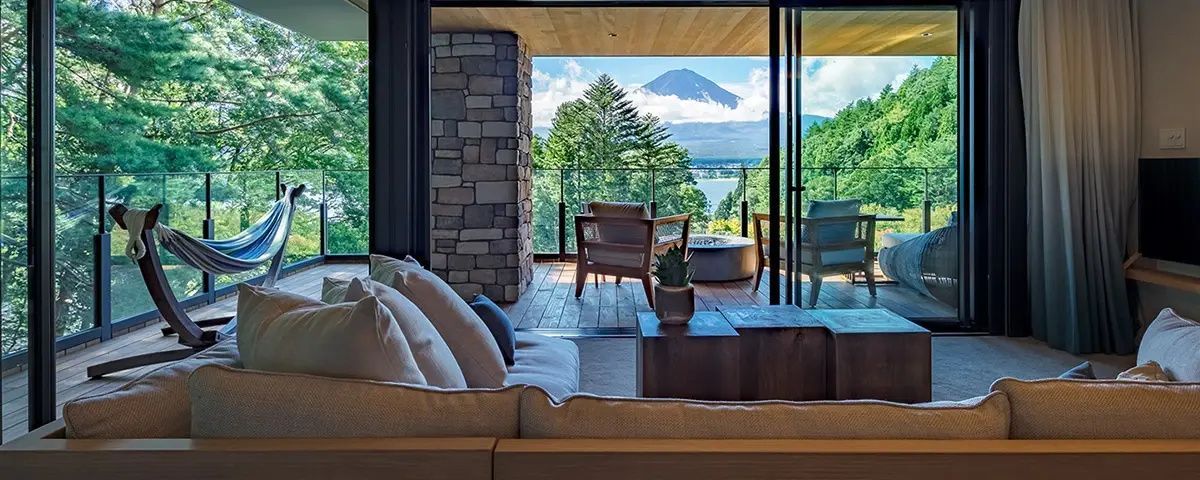 Sofa im Zimmer mit freier Sicht auf den Balkon und den Mount Fuji hinter dem See.
