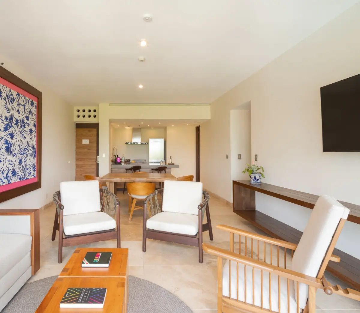 Offener Wohnbereich der Suite mit Sesseln, Couchtisch und Blick in die Küche.