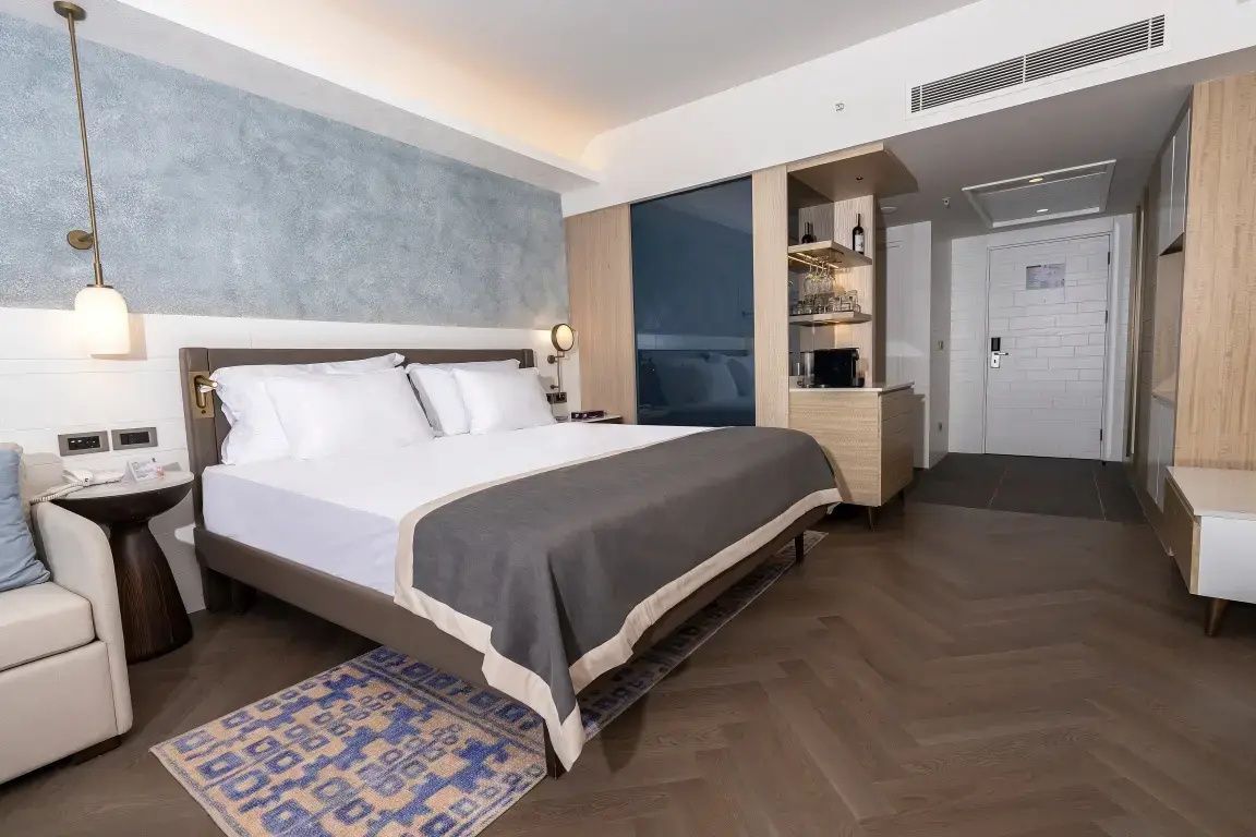 Schlafbereich im Hotelzimmer mit Doppelbett, Holzboden und integrierter Minibar.