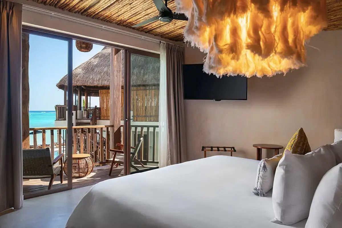 Schlafbereich mit großem Bett, großer Hängelampe und Zugang zum eigenen Balkon.