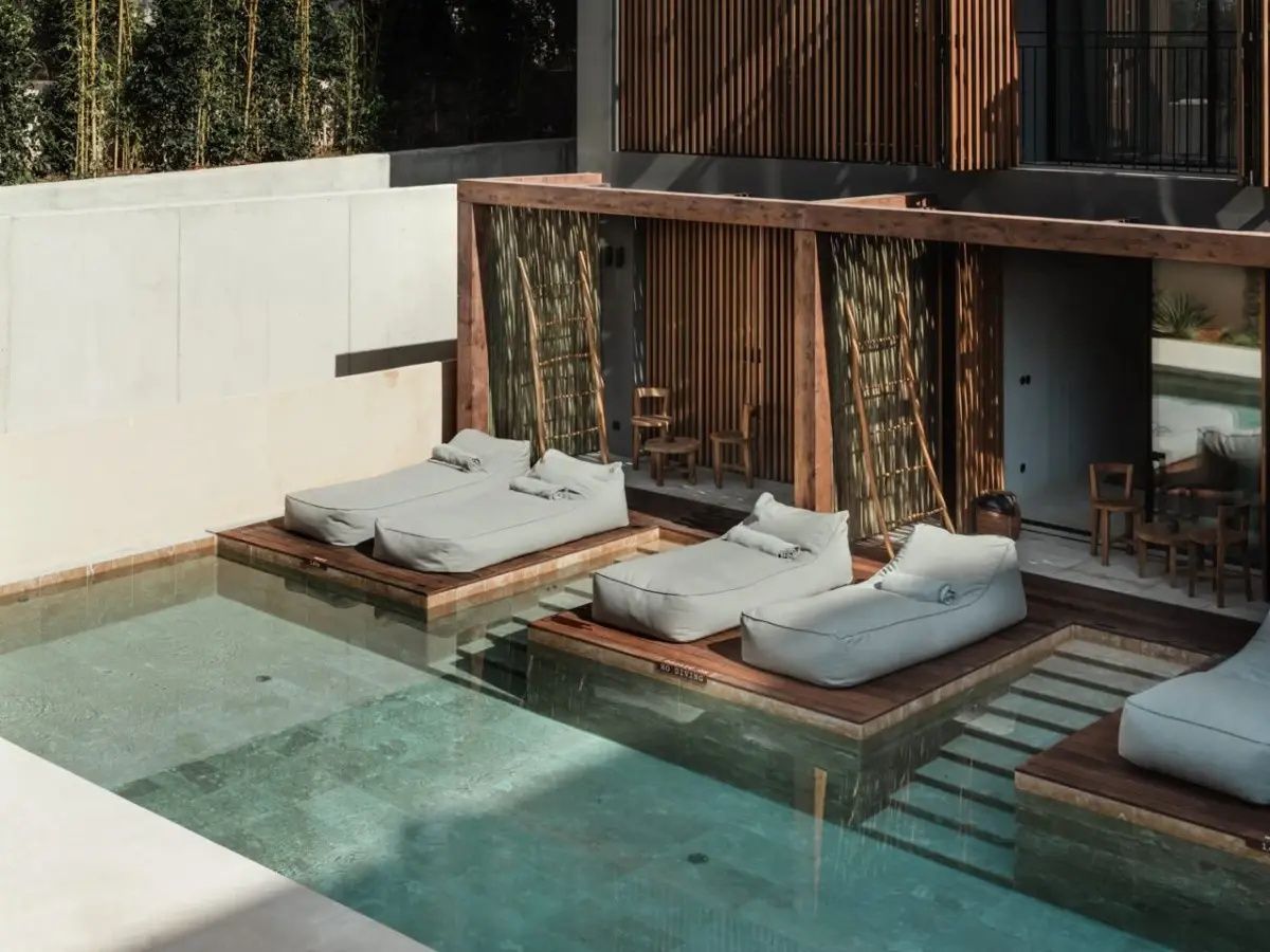 Bequeme Liegekissen auf Holzpodesten direkt in einem privaten Swim-up-Pool.