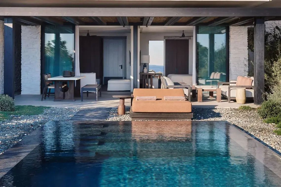 Terrasse mit einem privaten Pool, gepolsterten Sonnenliegen und Sitzgelegenheiten.
