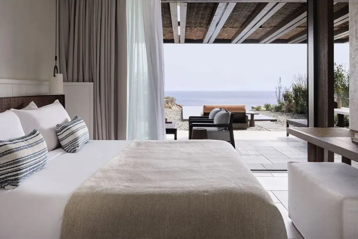 Blick vom Hotelzimmer über die private Terrasse mit Sesseln direkt auf das blaue Meer.