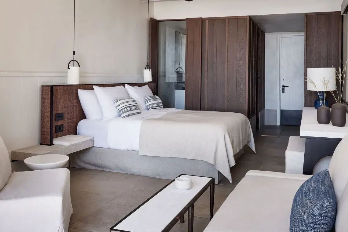 Modernes Doppelbett mit weißen Kissen und Holzverkleidung im Hotelzimmer.