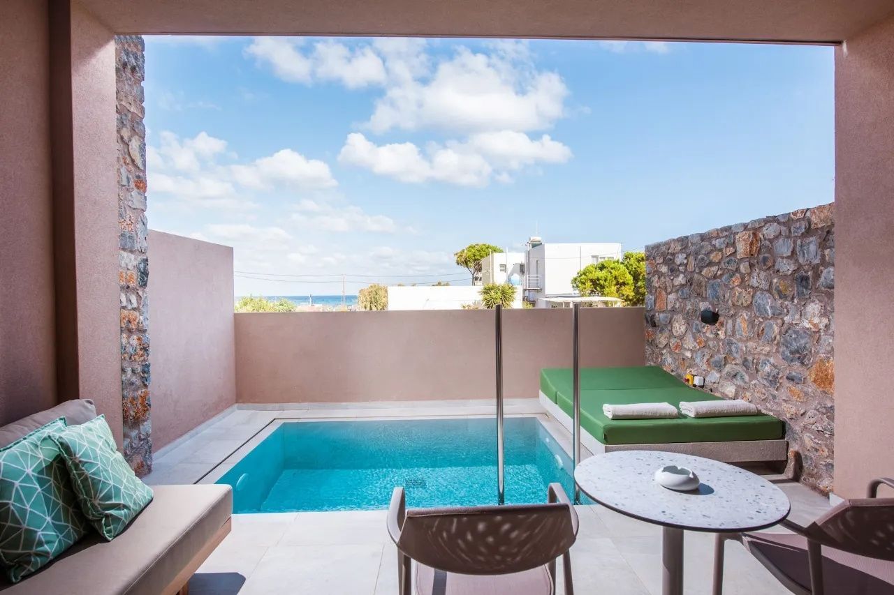 Terrasse mit eigenem kleinen Pool, grünem Tagesbett und Blick auf das Meer.